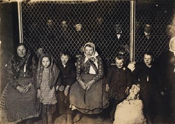 HINE, LEWIS W. (1874-1940) Family group at Ellis Island (with immigrants behind a hurricane fence).